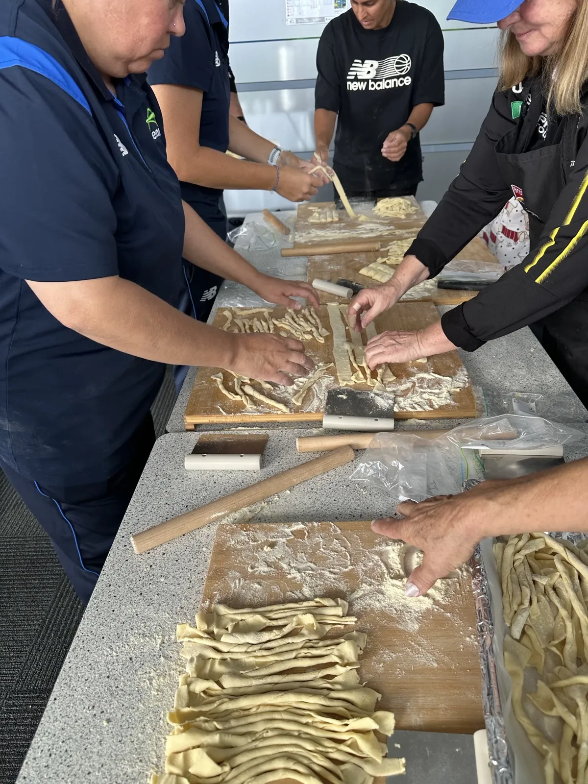 Tennis West team shaping fresh pasta by hand at an on-site workshop